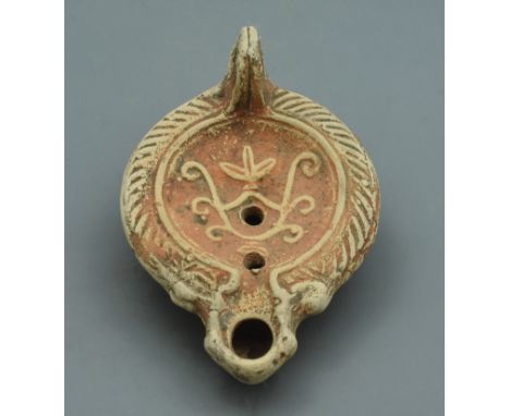A terracotta oil lamp with a floral wreath pattern design to the centre. - 120mm, 110 grams - ca.200-300AD - Property of a Br