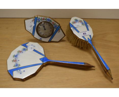 An Art Deco three piece guilloche enamelled dressing table set, comprising mirror, brush, and mantel clock