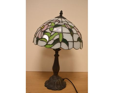 A Tiffany style glass table lamp with domed shade and raised on a moulded Art Nouveau style base, measuring 46cm high