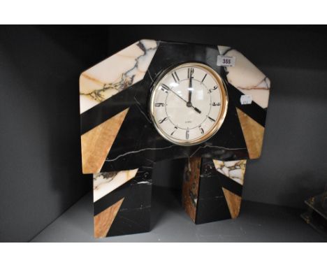 An Art Deco inspired stone sample mantel clock, the canted rectangular top raised on two pedestals, clock mechanism with quar
