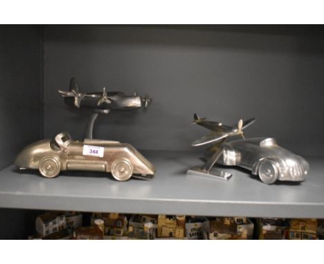 A group of vintage transport related desk ornaments, two vintage roadsters and two aeroplanes in white metal