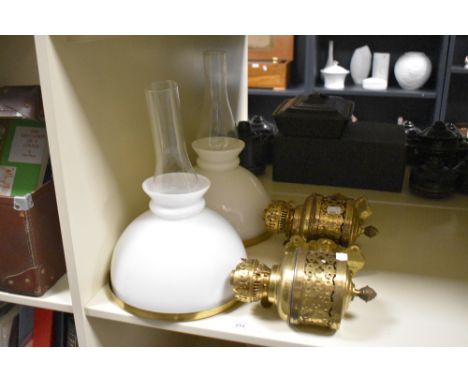 A pair of late 19th Century Gothic wall mounted brass oil lamp fittings, having banded quatrefoil design and milk glass shade