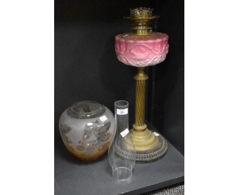 A Victorian oil lamp, having a moulded pink opaline glass reservoir above a twisted brass column, together with etched glass 