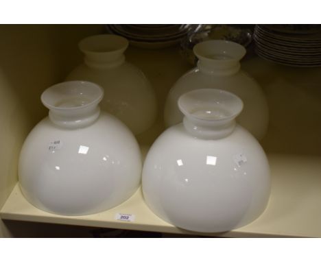 Four Victorian milk glass oil lamp shades, each measuring 21cm high