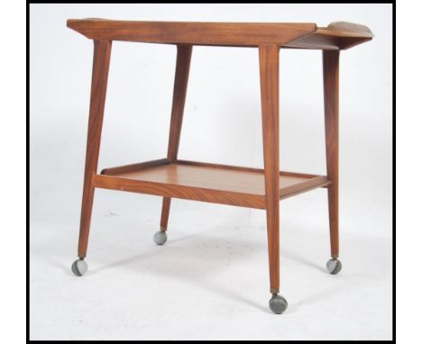 A 1970's / mid century retro teak wood buffet trolley of angular form being raised on tapering legs with castors having twin 