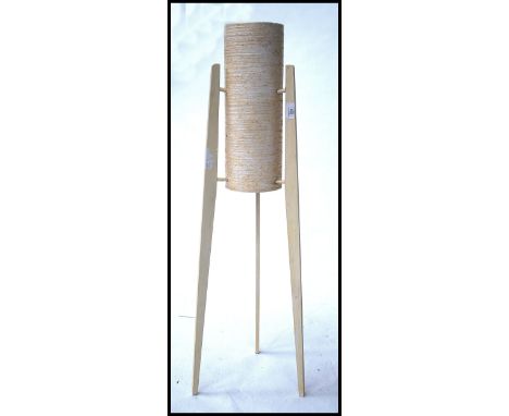 A retro 1960's teak and spun resin rocket floorstanding lamp, the white cylindrical centre flanked by three worked timber pai