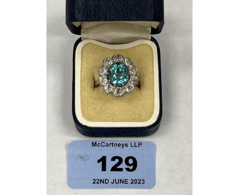 An aquamarine (?) and ten stone diamond cluster ring. In platinum marked PLAT, the centre stone 10mm high. 7g gross. Size M