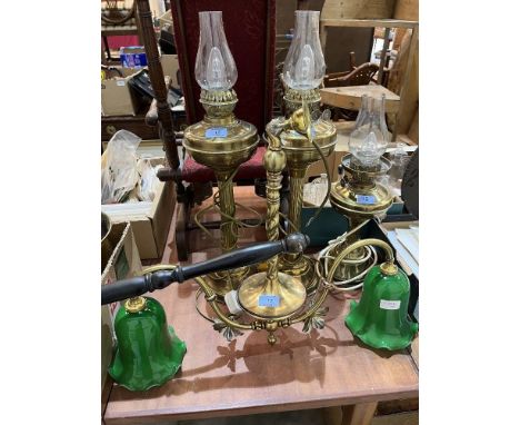A two light brass hanging lamp and three brass oil lamps converted to electric light