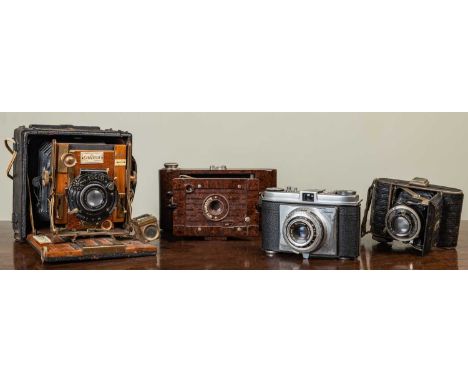 A collection of cameras to include a Sanderson 1/4 plate camera with leather body and Koilos lense, an Olympus Pen EE-2, A Ze