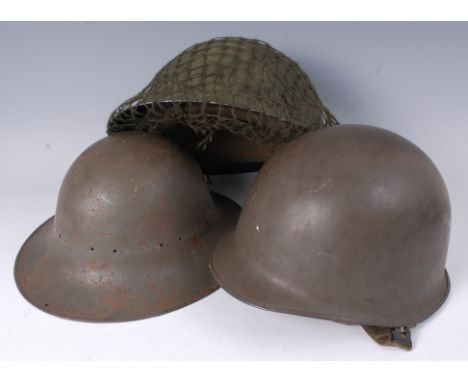 A post WW II Brodie pattern steel helmet, together with two others. (3)