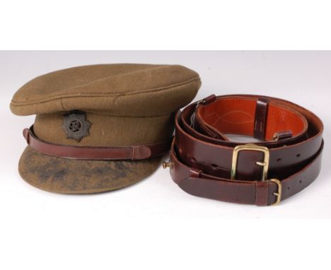 A Royal Army Service Corps peaked cap, together with a brown leather Sam Browne belt. (2)