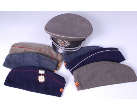 A DDR Army Officer's peaked cap, size 57, together with six East German cotton side caps. (7)