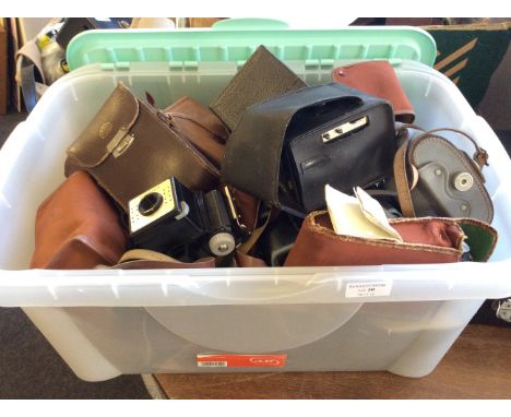 A box of cameras and camera equipment including cases and camera bodies.