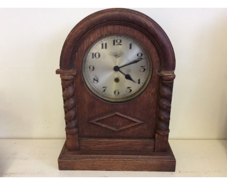 An ornamental mantelpiece clock with barley twist decoration.