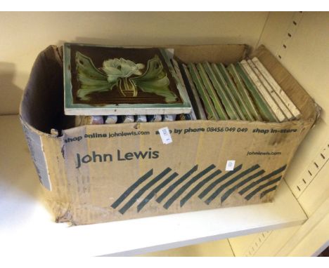 A box of ceramic tiles with various floral patterns.