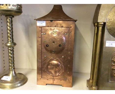A copper coloured Art Nouveau style mantle clock, decorated with the profile of a lady.