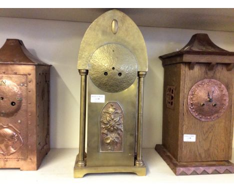 A brass Art Nouveau style mantle clock wiry floral deviation to centre.