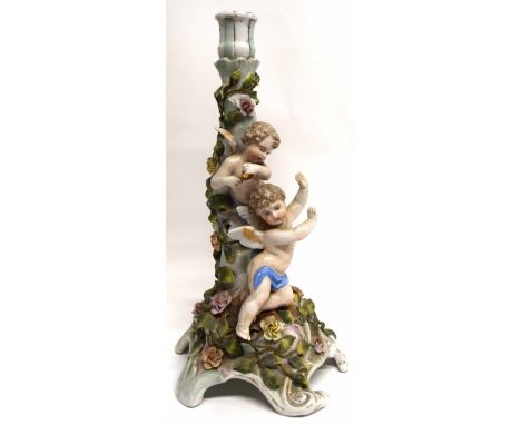 Continental porcelain candlestick, the main decoration with trailing flowers and two cherubs, 33cm high   