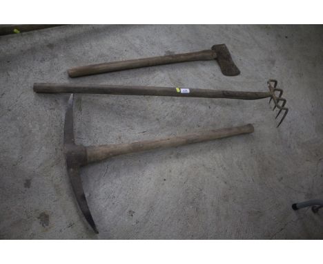 A small quantity of wooden handled tools to include crome, pick axe, axe, etc.