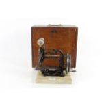 A small Weir sewing machine "The Globe Type" set on a marble plinth with original wooden case