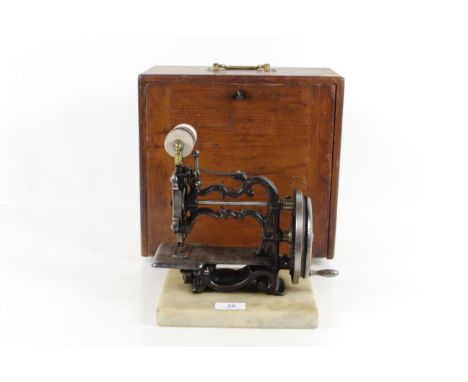 A small Weir sewing machine "The Globe Type" set on a marble plinth with original wooden case circa 1870's