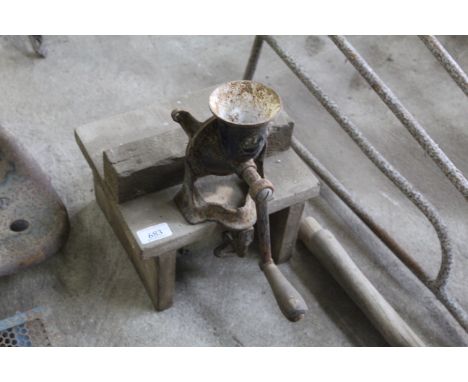 A vintage coffee grinder mounted to wood base