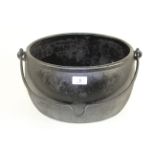 An oval 2 gallon cast iron cooking cauldron with swing handle