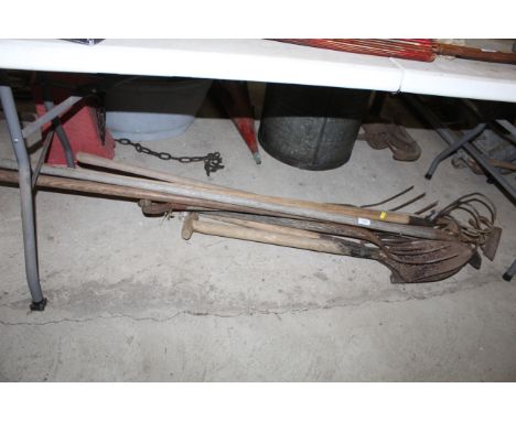 A quantity of wooden long handled tools to include tined cultivators, spades, hoe's, digging fork etc.