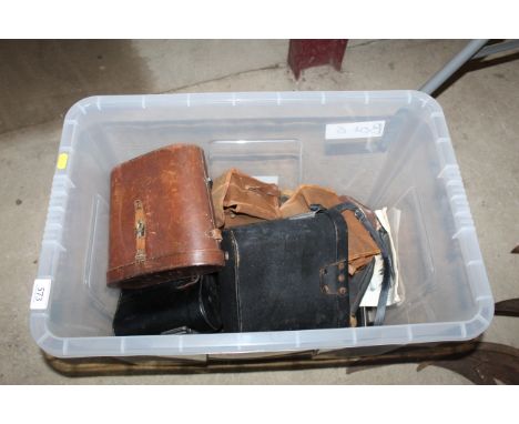 A box containing various canvas and leather camera cases