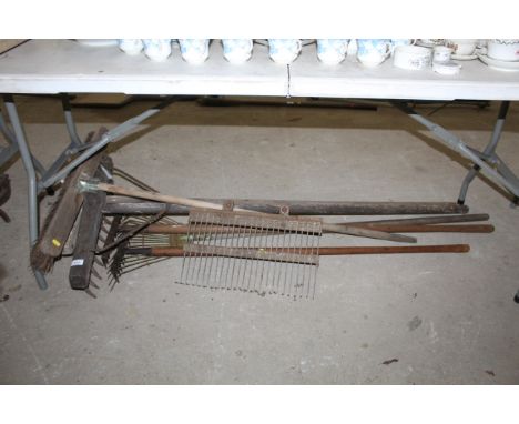 A quantity of various wooden handled tools to include brooms, rakes etc.