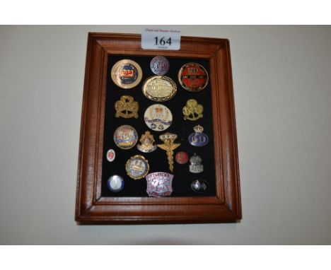 A framed collection of enamel and other badges