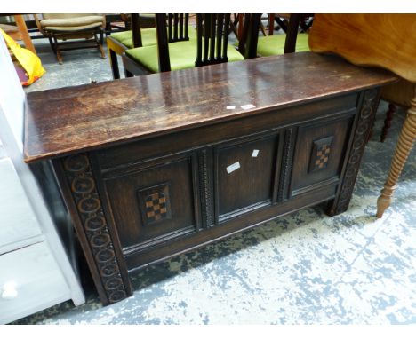 AN OAK THREE PANEL FRONTED COFFER INLAID WITH TWO CHEQUER SHIELDS