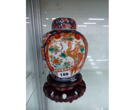 A JAPANESE IMARI JAR, COVER AND WOODEN STAND