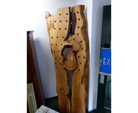 A TREE TRUNK PANEL PIERCED AS A BOTTLE RACK.   W 94 x H 244cms.