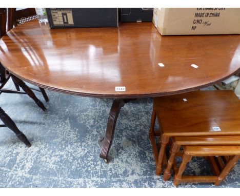 A MAHOGANY BREAKFAST TABLE ON THREE REEDED LEGS WITH BRASS CASTOR FEET