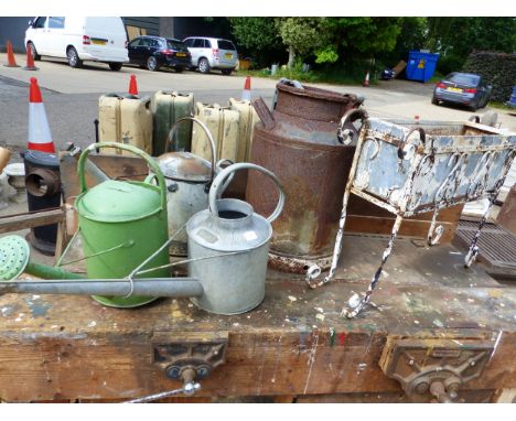 A SMALL MILK CHURN, 3 GALVANISED WATERING CANS AND A RECTANGULAR PLANTER IN A PAINTED WROUGHT IRON STAND