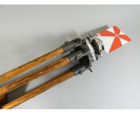 A pair of vintage surveyors measuring tools, with red and white level gauges, on wooden tripod bases, tallest tripod to measu