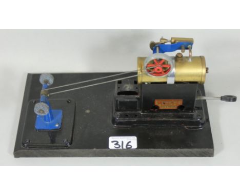 A Mamod stationary steam engine, complete with burner, mounted on a painted wooden base.