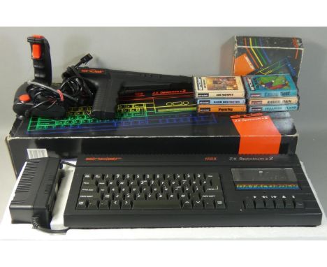 A boxed Sinclair ZX Spectrum +2A in black, with power supply unit, manual and television lead, together with 6 game pack, joy