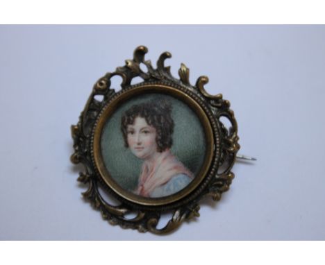 A LATE 19TH / EARLY 20TH CENTURY CIRCULAR PORTRAIT MINIATURE OF A LADY WITH A PINK SHAWL, in a circular decorative gilt metal