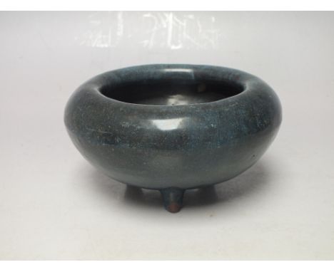 A BLUE CERAMIC BOWL UPON THREE PEG FEET, with fold over rim, Dia 11.75 cm