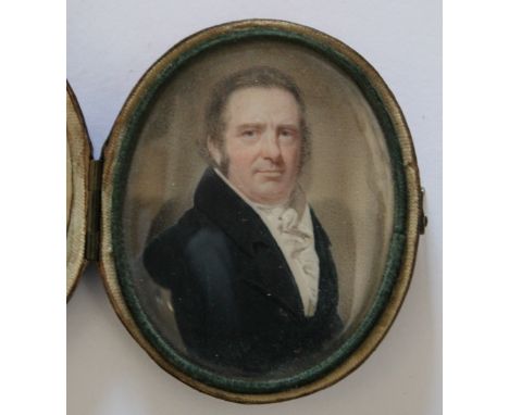A 19TH CENTURY OVAL PORTRAIT MINIATURE OF A GENTLEMAN IN A BLUE COAT, in cased leather framed, unsigned, framed and glazed, 7