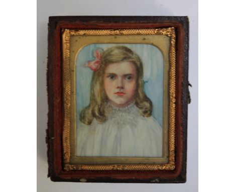 A LATE 19TH / EARLY 20TH CENTURY PORTRAIT MINIATURE OF A YOUNG GIRL IN A WHITE DRESS WITH PINK BOW, in gilt metal frame in a 