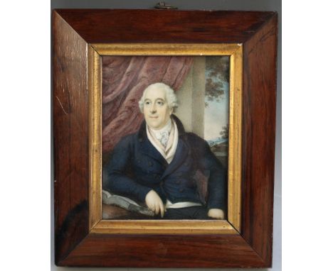 A 19TH CENTURY PORTRAIT MINIATURE OF A SEATED GENTLEMAN IN A BLUE COAT WITH BOOK BY HIS SIDE, landscape in background, in a f