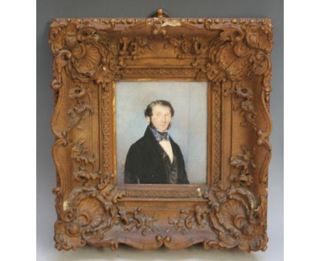 A LATE 19TH / EARLY 20TH CENTURY PORTRAIT MINIATURE OF GENTLEMAN IN BLACK COAT AND BLUE AND WHITE BOW TIE, in a gold swept fr