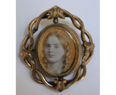 A LATE 19TH / EARLY 20TH CENTURY OVAL PORTRAIT MINIATURE OF A GIRL WITH BLONDE HAIR, in a pinchbeck spinner brooch frame, uns