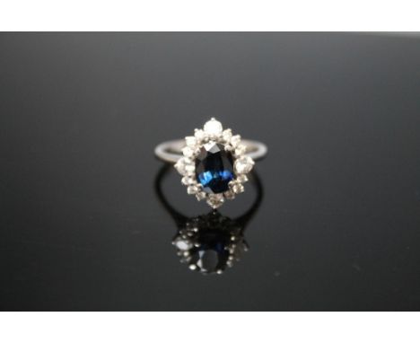 A SAPPHIRE AND DIAMOND RING, set in white metal stamped 18K, the central sapphire measuring approx 8mm by 6mm, ring size O