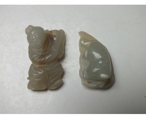 A JADE FIGURAL PENDANTS IN THE FORM OF A BAT ON A LEAF, finely carved in shallow relief, H 3.9 cm, together with a carved fig