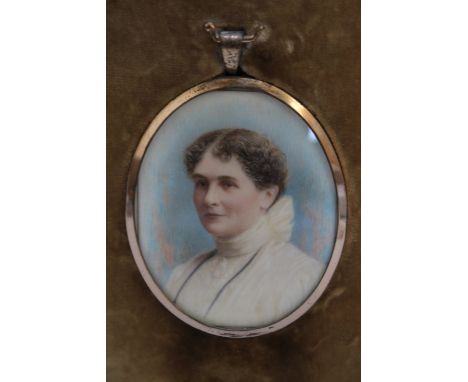 A LATE 19TH / EARLY 20TH CENTURY OVAL PORTRAIT MINIATURE OF A LADY IN A WHITE DRESS WITH BROWN HAIR, in a gilt metal frame, s