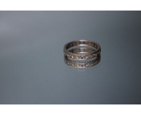 AN 18KT WHITE GOLD DIAMOND SET BAND, having nine small brilliant cut diamonds, approx weight 5.2g, ring size Q